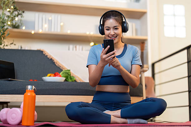 istock Yoga and Technology. Young woman using smartphone while practicing yoga at home. 2226245720