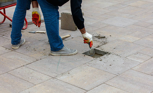 istock A man is working on a sidewalk, using a trowel to fill in a hole 2226245772
