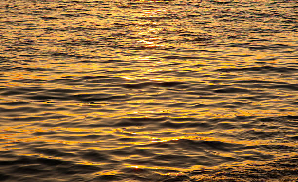 istock The water is calm and the sun is setting, creating a serene 2226245815