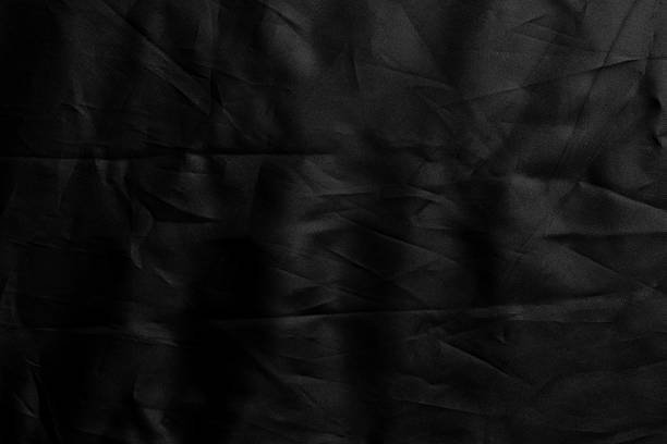 Crumpled wavy black fabric with wrinkled texture.