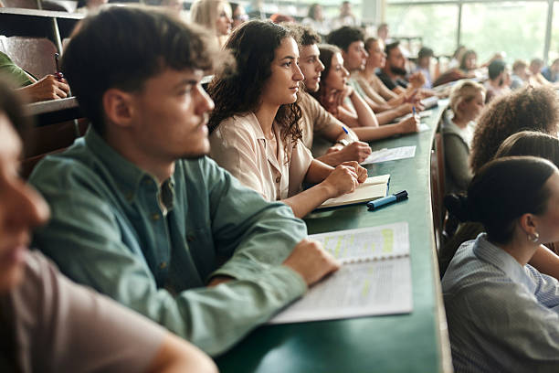 istock Young female student and her friends having a class in lecture hall. 2226246576