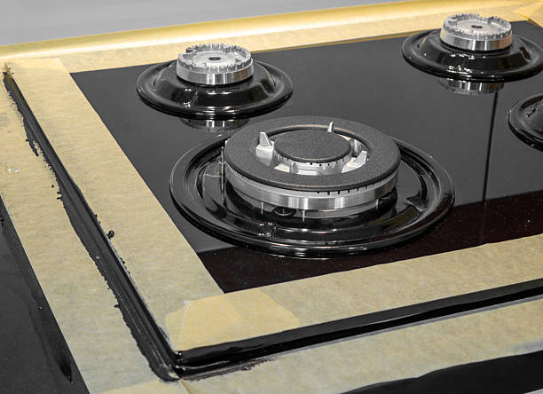 istock A specialist applying silicone mass into the gaps between a gas hob and a countertop, interior finishing, kitchen accessories, kitchen equipment 2226247077