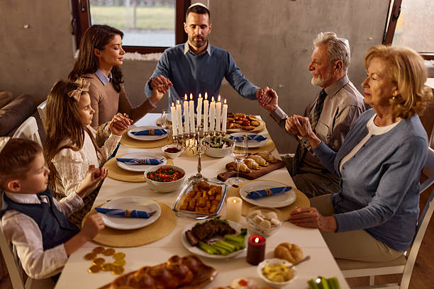 istock Extended family praying before lunch on Hanukkah. 2226247985