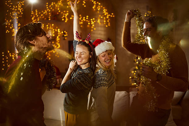 Young cheerful couples having fun while dancing during a party on Christmas at home.