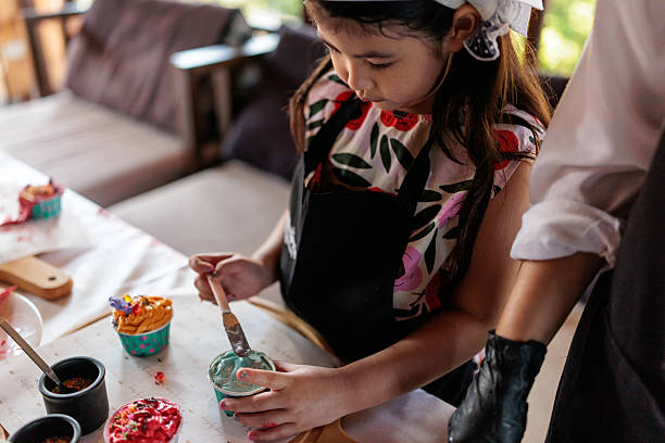 Little girl decorating a cupcake