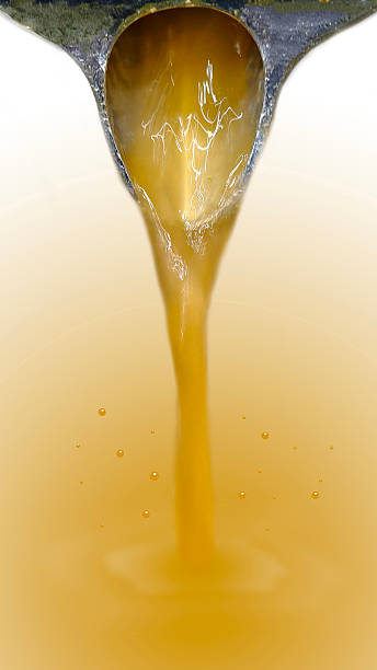 istock Orange juice from a juicer is flowing onto an orange background. 2226255864