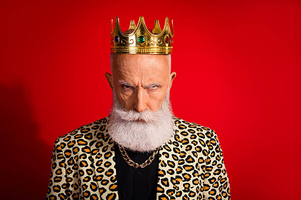 A mature man posing with a regal crown, dressed in a leopard-patterned jacket against a vibrant red background, highlighting a unique, eccentric, and stylish character.