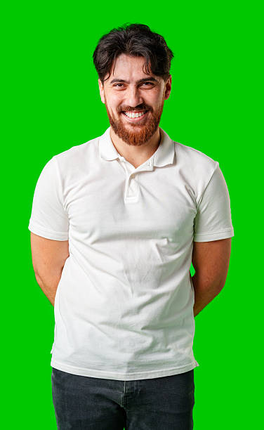 istock A smiling young man with a beard poses against a bright green background 2226259717