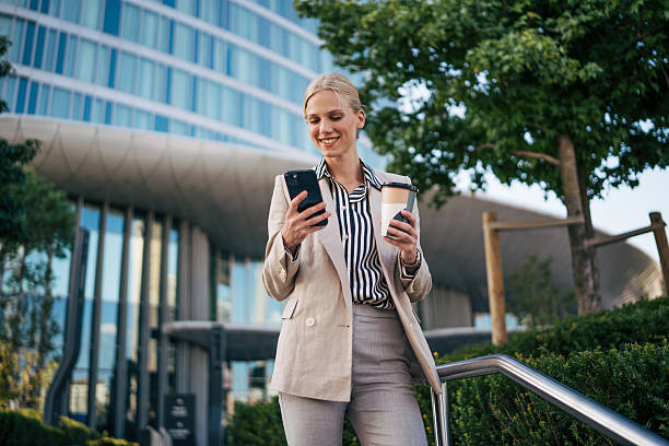 istock Businesswoman using smartphone and drinking coffee outdoors 2226263071