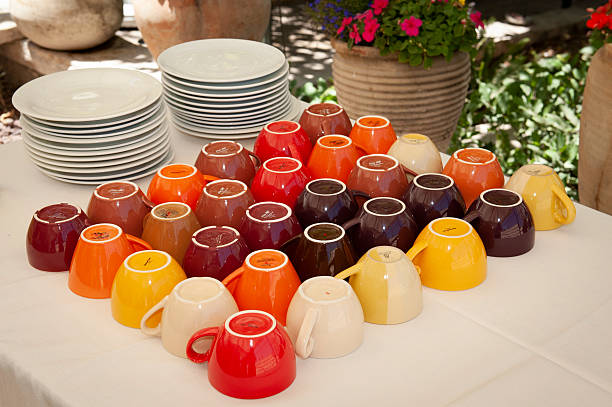 Patterned display of rows of multi-colored, ceramic, upside down mugs for coffee and tea.