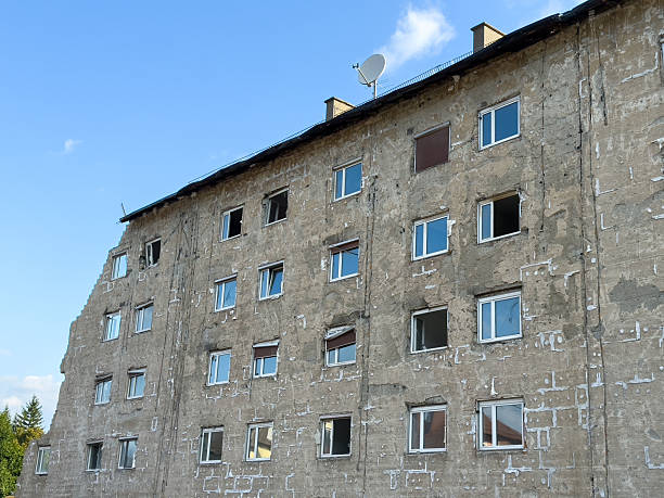 istock Dilapidated building exterior with weathered walls and satellite dish under clear sky 2226265521