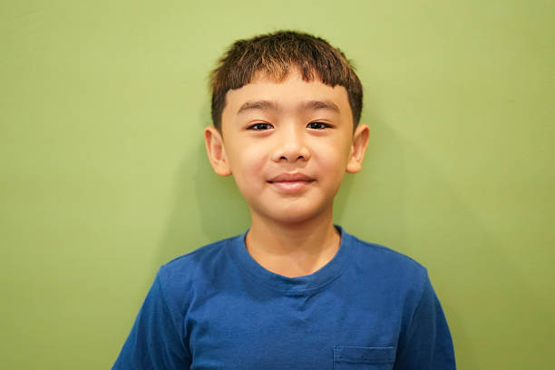 Close-up Smiling boy face on green wall