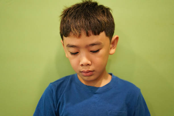 Close-up Boy sad face on green wall