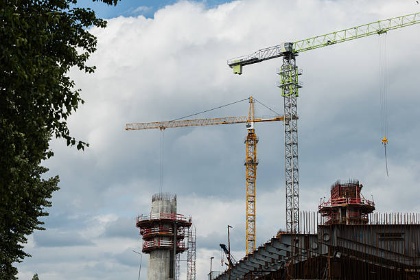 istock Construction site with cranes and scaffolding against a cloudy sky showcasing urban development 2226269371
