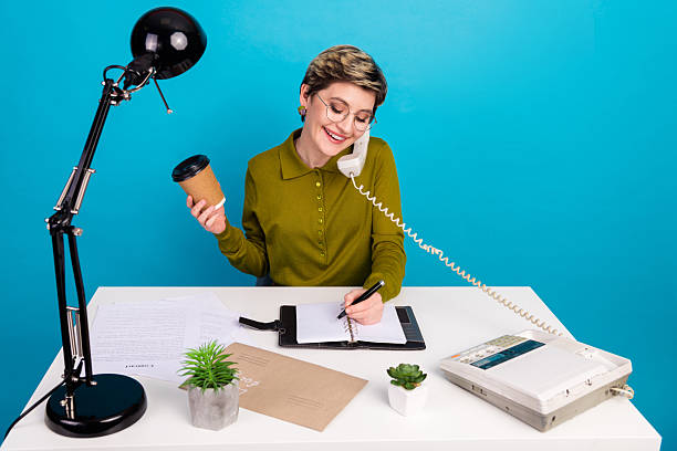 istock Confident Young Woman Working in Style with Retro Office Equipment and a Relaxed Pose on Vibrant Blue Background 2226269775