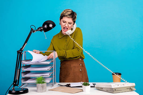 Cheerful young businesswoman multitasking in office, speaking on phone, managing work tasks, and showing vibrant energy