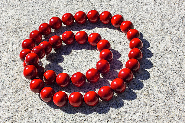Beads in the shape of a necklace on a wooden table.