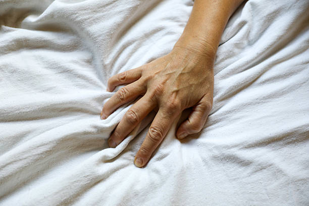 istock Female Hand Grabbing White Bed Sheet in Close-Up 2226271394