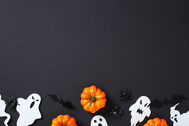 istock Flat lay Halloween decor on black background with pumpkins, ghosts, bats, and spiders. Dark festive scene with empty copy space 2226272166