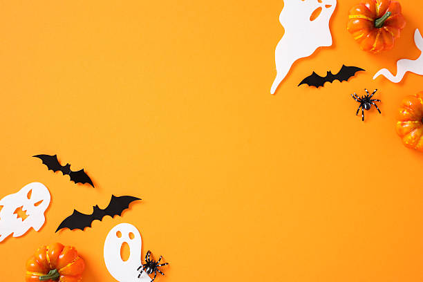 istock Flat lay Halloween elements: pumpkins, ghosts, bats, spiders, and webs on vibrant orange background 2226272192