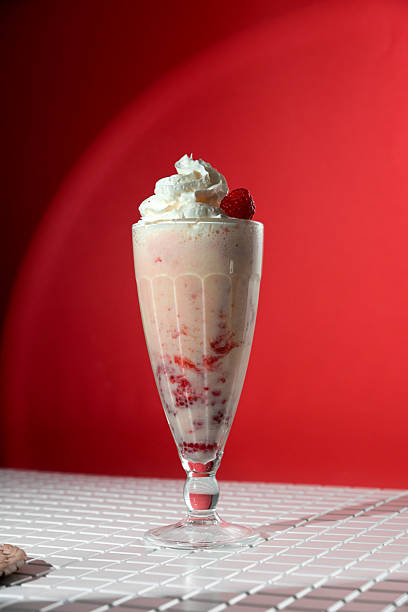 istock Milkshake with berry topping and foam on red background 2226274465