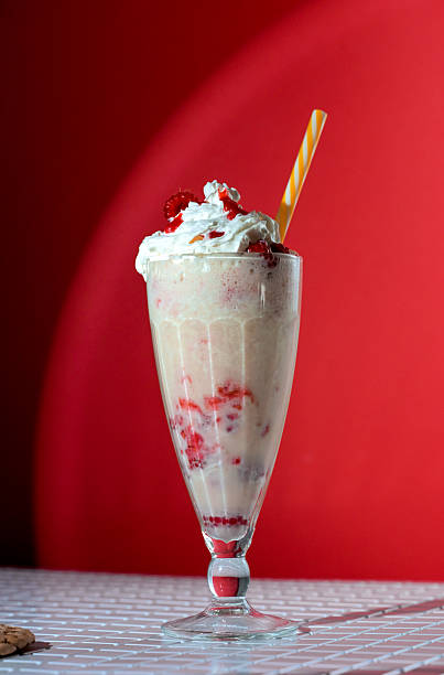 istock Milkshake with berry topping and foam on red background 2226274466