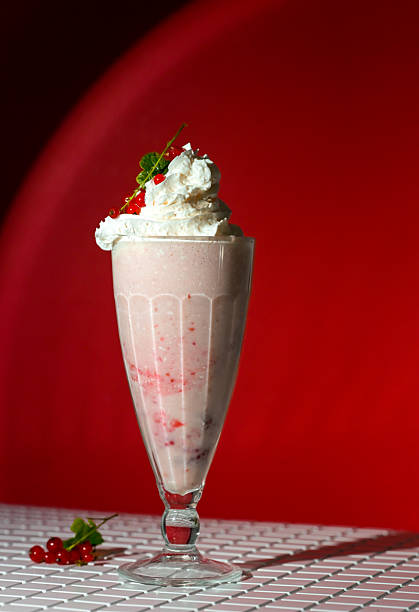 istock Milkshake with berry topping and foam on red background 2226274484