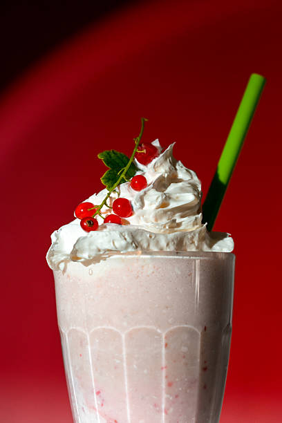istock Milkshake with berry topping and foam on red background 2226274486