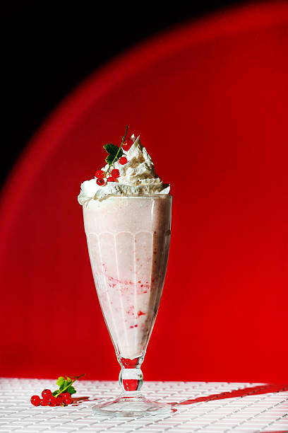 istock Milkshake with berry topping and foam on red background 2226274487