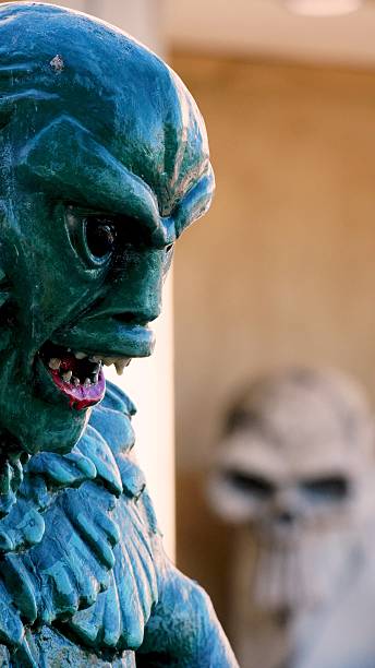 istock Scary Halloween monster statue roaring with skull in the background 2226276625
