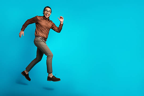 istock Cheerful young man jumping confidently against a vibrant blue background expressing joy, motivation 2226280268