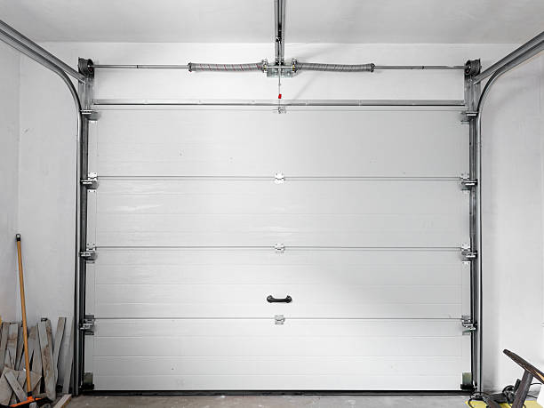istock Automatic sectional garage door with remote control, view from the inside of the garage on the mechanism 2226280357