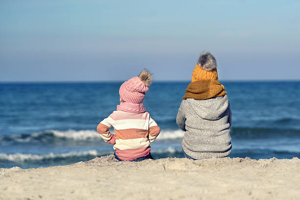 Autumn Beach Moments: Children Gazing at the Sea