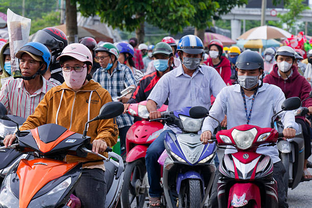 Vinh Long, Vietnam June 07, 2025 - A dense flow of Vietnamese industrial park workers on motorbikes commuting home during the busy afternoon rush hour in Hoa Phu.