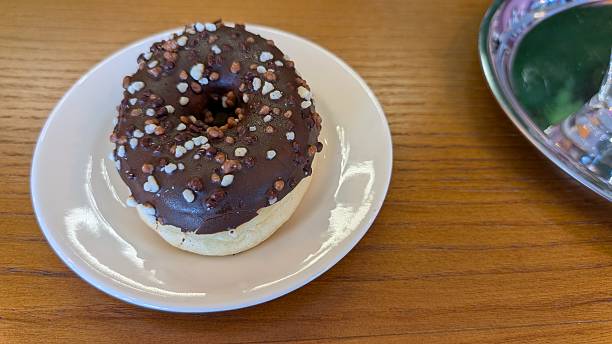 Enjoy a Chocolate Donut topped with Colorful Sprinkles, elegantly arranged on a Plate