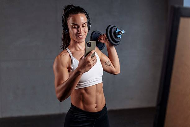 istock Fit Woman Lifting Dumbbell and Smiling During Workout 2226285837