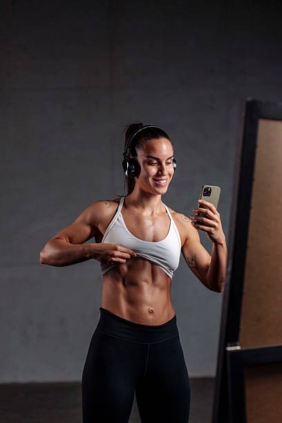 istock Fit Athletic Woman Checking Abs in Mirror 2226285840