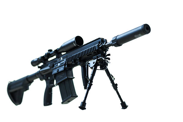 Detailed view of a modern tactical assault rifle equipped with a scope, suppressor, and bipod, captured against a white background.