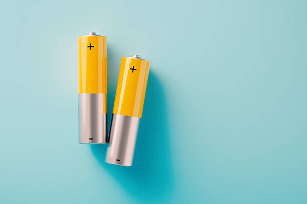 Yellow and silver disposable batteries on blue background.