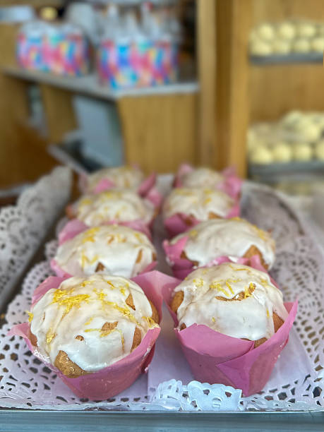 istock muffins or cupcakes in pink cupcake liners, with other assorted baked goods blurred in the background. 2226290370