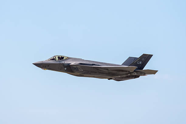 Dugny, France - June 20, 2025: Left-side view of a U.S. Air Force F-35 Lightning II, a multirole stealth strike fighter developed by american manufacturer Lockheed Martin, in low altitude flight.