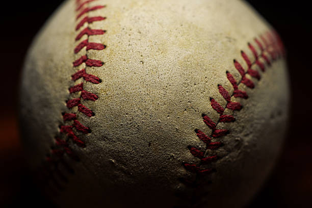 A closeup view of a baseball rotating in flight.  The spinning baseball is isolated on a white background.