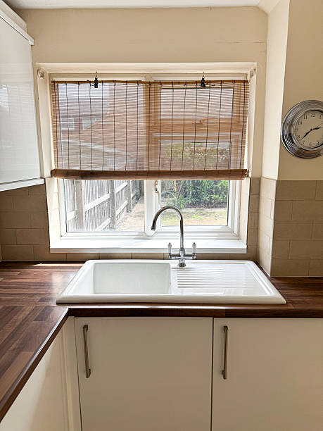 istock Image of kitchen with white ceramic sink and draining board, basin window, bamboo blind for privacy 2226297150