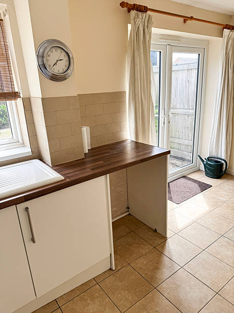 istock Image of modern rental kitchen with white gloss wall cabinets, wood-effect laminate worktop, durable tiled flooring /  practical interior, landlord properties 2226297165