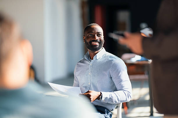 Smiling Man Participating in a Collaborative Business Meeting in Modern Office Setting