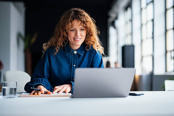 istock Female Employee Working on Laptop in a Modern Office Setting 2226298774