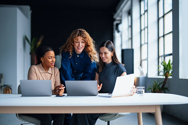 Businesswomen Collaborating on Laptops in a Modern Office Setting