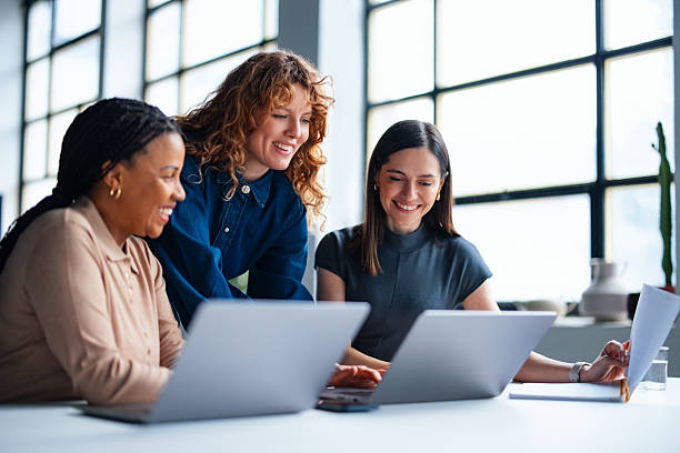 istock Three Women Collaborating on Laptops in a Bright Office Environment 2226298870