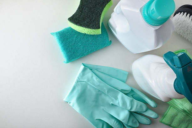 istock Cleaning products in green on white table top view 2226298984