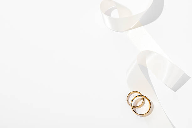 istock Golden wedding rings and ribbon on white background, top view. Space for text 2226304809